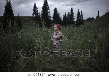 Picture - Caucasian woman standing in remote field. Fotosearch