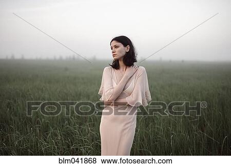 Caucasian woman standing in remote field View Large Photo Image Stock Photo - Caucasian woman standing in remote field. Fotosearch