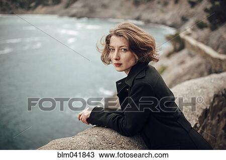 Caucasian woman standing on cliff over coastline View Large Photo Image Stock Image - Caucasian woman standing on cliff over coastline. Fotosearch