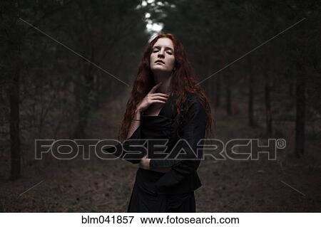 Stock Photo - Caucasian woman walking on forest path. Fotosearch
