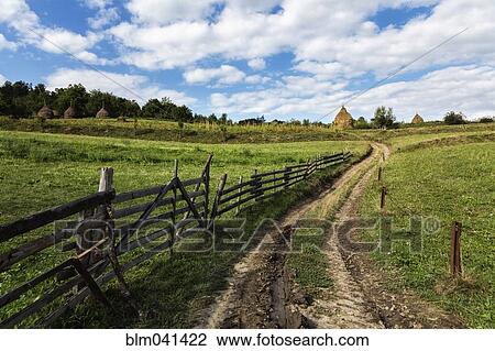 Stock Image - Dirt road in rural farm fields. Fotosearch
