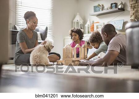 Stock Image - Family playing with building blocks in living room. Fotosearch