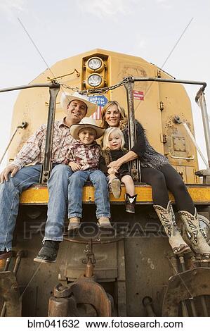 Stock Image - Family sitting on vintage train. Fotosearch