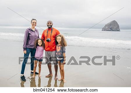 Picture - Family smiling on beach. Fotosearch