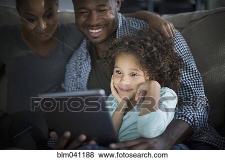 Family using digital tablet on sofa View Large Photo Image Stock Photo - Family using digital tablet on sofa. Fotosearch