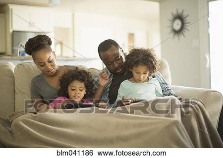 Family using digital tablets on sofa View Large Photo Image Stock Photograph - Family using digital tablets on sofa. Fotosearch