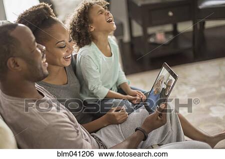 Stock Photograph - Family video chatting with digital tablet. Fotosearch