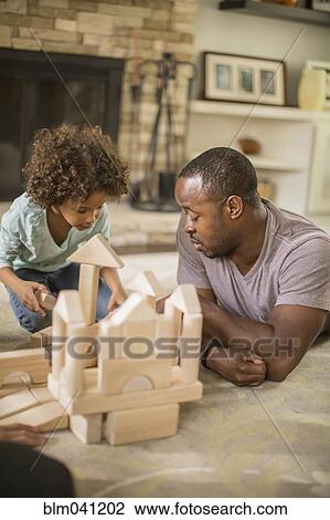 Father and daughter playing with building blocks in living room View Large Photo Image Stock Image - Father and daughter playing with building blocks in living room. Fotosearch