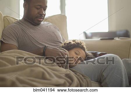 Father and daughter snuggling on sofa View Large Photo Image Picture - Father and daughter snuggling on sofa. Fotosearch