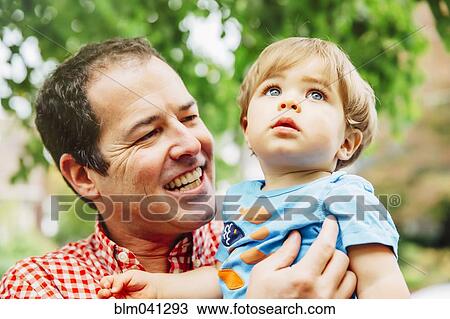Father holding baby son outdoors View Large Photo Image Stock Image - Father holding baby son outdoors. Fotosearch