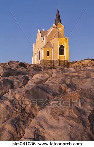 Stock Photograph - Felsenkirche illuminated on rocky hilltop, Luderitz, Karas Province, Namibia. Fotosearch