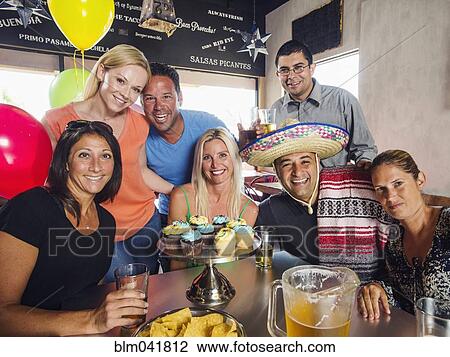Stock Image - Friends celebrating birthday in cafe. Fotosearch