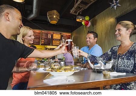 Stock Photography - Friends toasting in cafe. Fotosearch