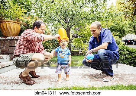 Gay fathers playing with baby son outdoors View Large Photo Image Stock Image - Gay fathers playing with baby son outdoors. Fotosearch