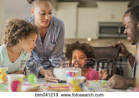 Stock Photo - Girl admiring birthday cake at party. Fotosearch