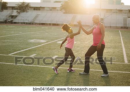 Grandmother and granddaughter high-fiving on football field View Large Photo Image Stock Image - Grandmother and granddaughter high-fiving on football field. Fotosearch