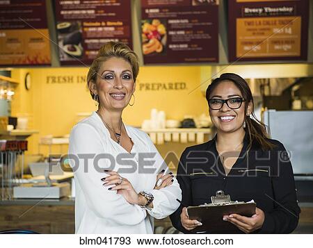 Hispanic business owner and employee smiling in cafe View Large Photo Image Stock Image - Hispanic business owner and employee smiling in cafe. Fotosearch