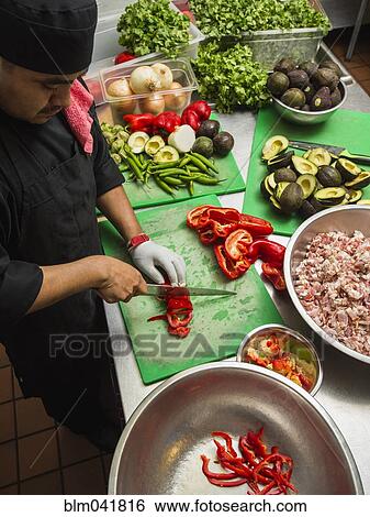 Hispanic chef cutting vegetables in kitchen View Large Photo Image Stock Photograph - Hispanic chef cutting vegetables in kitchen. Fotosearch