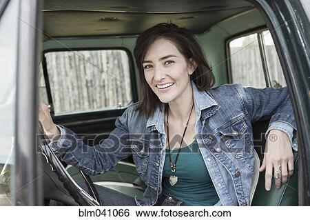 Stock Photograph - Hispanic woman sitting in truck. Fotosearch