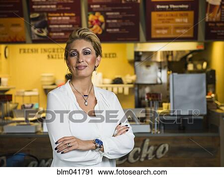 Stock Image - Hispanic woman smiling in cafe. Fotosearch