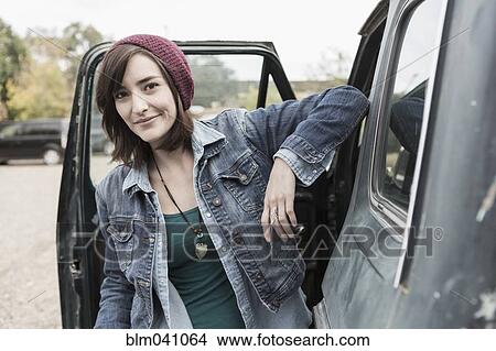 Picture - Hispanic woman standing at truck. Fotosearch