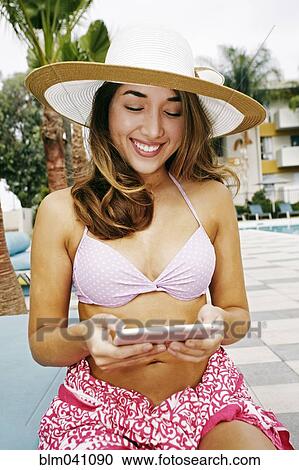 Stock Image - Hispanic woman using digital tablet outdoors. Fotosearch