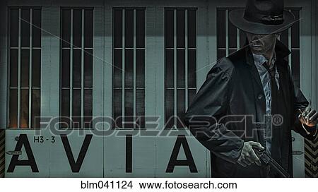 Man carrying gun near airport hangar View Large Photo Image Picture - Man carrying gun near airport hangar. Fotosearch