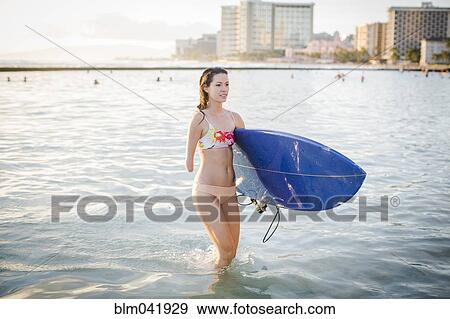Mixed race amputee carrying surfboard in ocean View Large Photo Image Stock Photo - Mixed race amputee carrying surfboard in ocean. Fotosearch