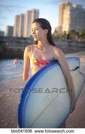 Mixed race amputee carrying surfboard on beach View Large Photo Image Stock Photograph - Mixed race amputee carrying surfboard on beach. Fotosearch