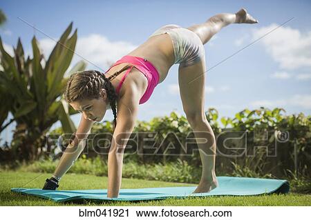 Stock Image - Mixed race amputee practicing yoga in grass. Fotosearch