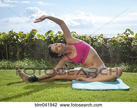 Stock Image - Mixed race amputee practicing yoga in grass. Fotosearch