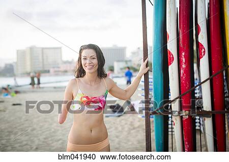 Stock Image - Mixed race amputee smiling on beach. Fotosearch