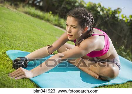 Stock Image - Mixed race amputee stretching in grass. Fotosearch