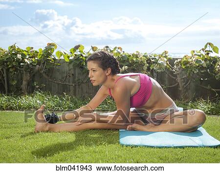Stock Image - Mixed race amputee stretching in grass. Fotosearch