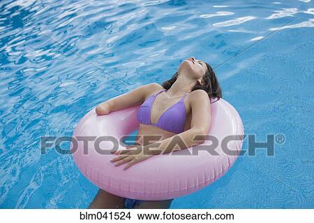 Picture - Mixed race amputee woman swimming in pool. Fotosearch