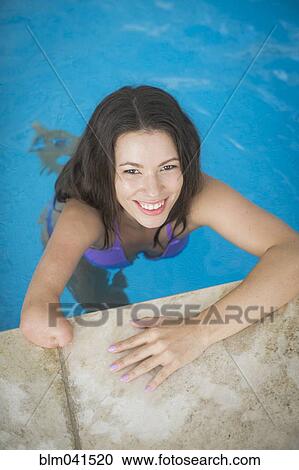 Stock Image - Mixed race amputee woman swimming in pool. Fotosearch