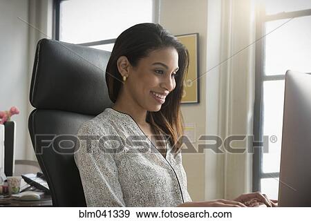 Stock Photo - Mixed race businesswoman working in office. Fotosearch