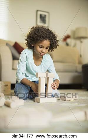 Stock Photo - Mixed race girl playing with building blocks. Fotosearch