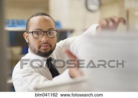 Stock Image - Mixed race server with down syndrome working in restaurant. Fotosearch