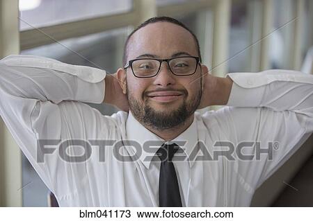 Stock Image - Mixed race server with down syndrome smiling in restaurant. Fotosearch
