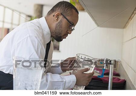 Mixed race server with down syndrome filling pitcher in restaurant View Large Photo Image Stock Photo - Mixed race server with down syndrome filling pitcher in restaurant. Fotosearch