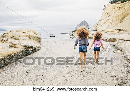 Mixed race sisters walking on beach View Large Photo Image Stock Photo - Mixed race sisters walking on beach. Fotosearch
