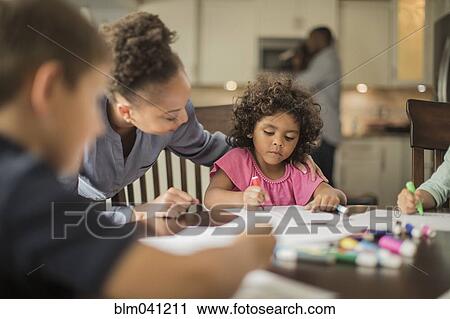 Stock Image - Mother and children drawing in kitchen. Fotosearch