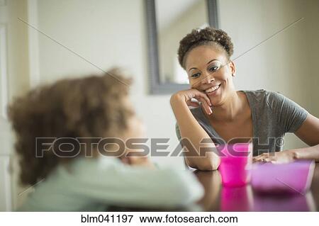 Mother and daughter eating at table View Large Photo Image Stock Photo - Mother and daughter eating at table. Fotosearch