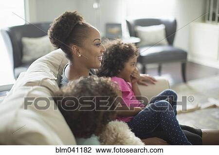 Mother and daughters watching television on sofa View Large Photo Image Stock Image - Mother and daughters watching television on sofa. Fotosearch