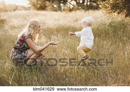 Mother and son playing in field View Large Photo Image Stock Photo - Mother and son playing in field. Fotosearch