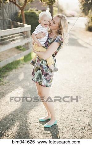 Stock Photograph - Mother holding son outdoors. Fotosearch