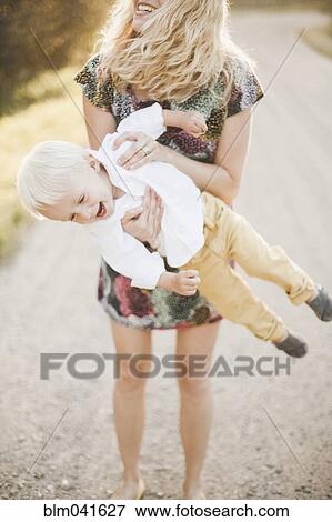 Mother lifting son outdoors View Large Photo Image Stock Photo - Mother lifting son outdoors. Fotosearch