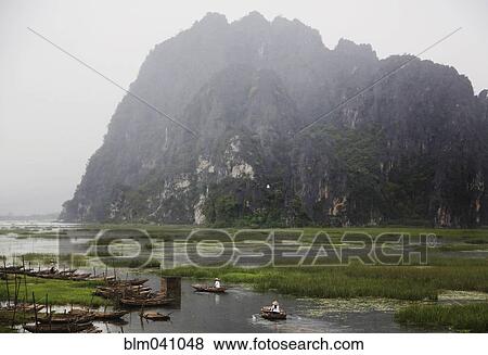 Stock Photo - Mountains over canoes in remote marsh. Fotosearch