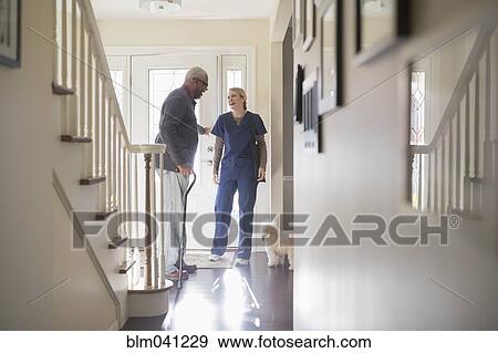 Stock Photo - Nurse and patient talking in hallway. Fotosearch